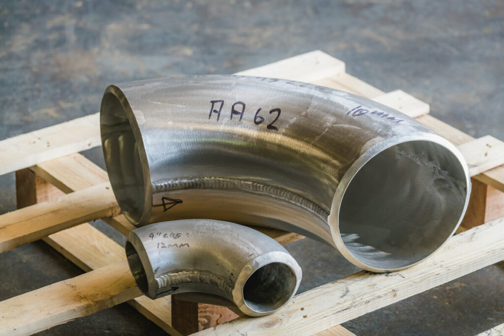 a big and small curved aluminium pipe