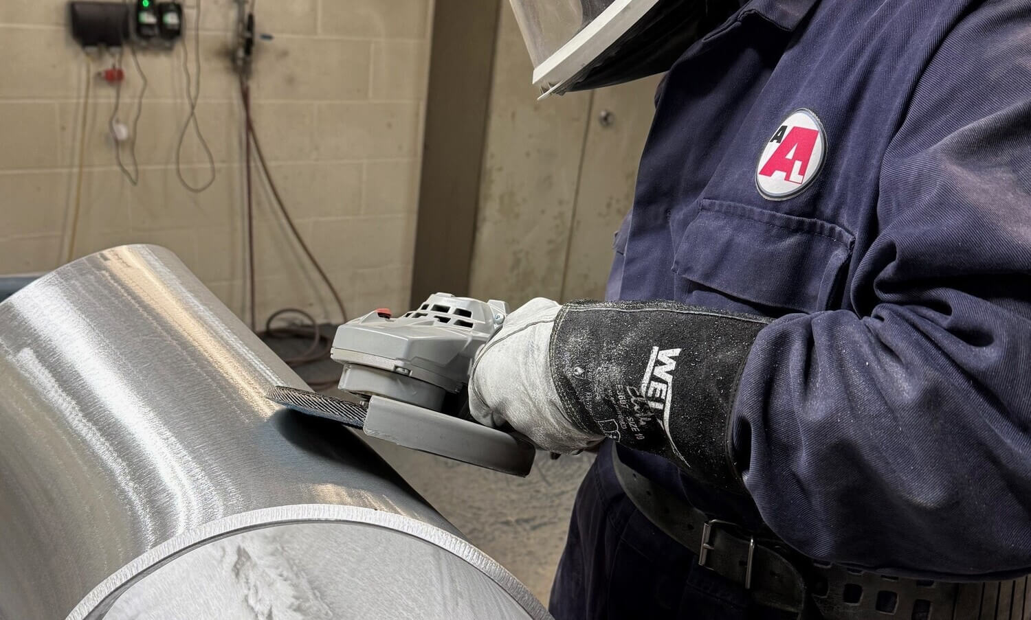 man polishing an aluminium pipe