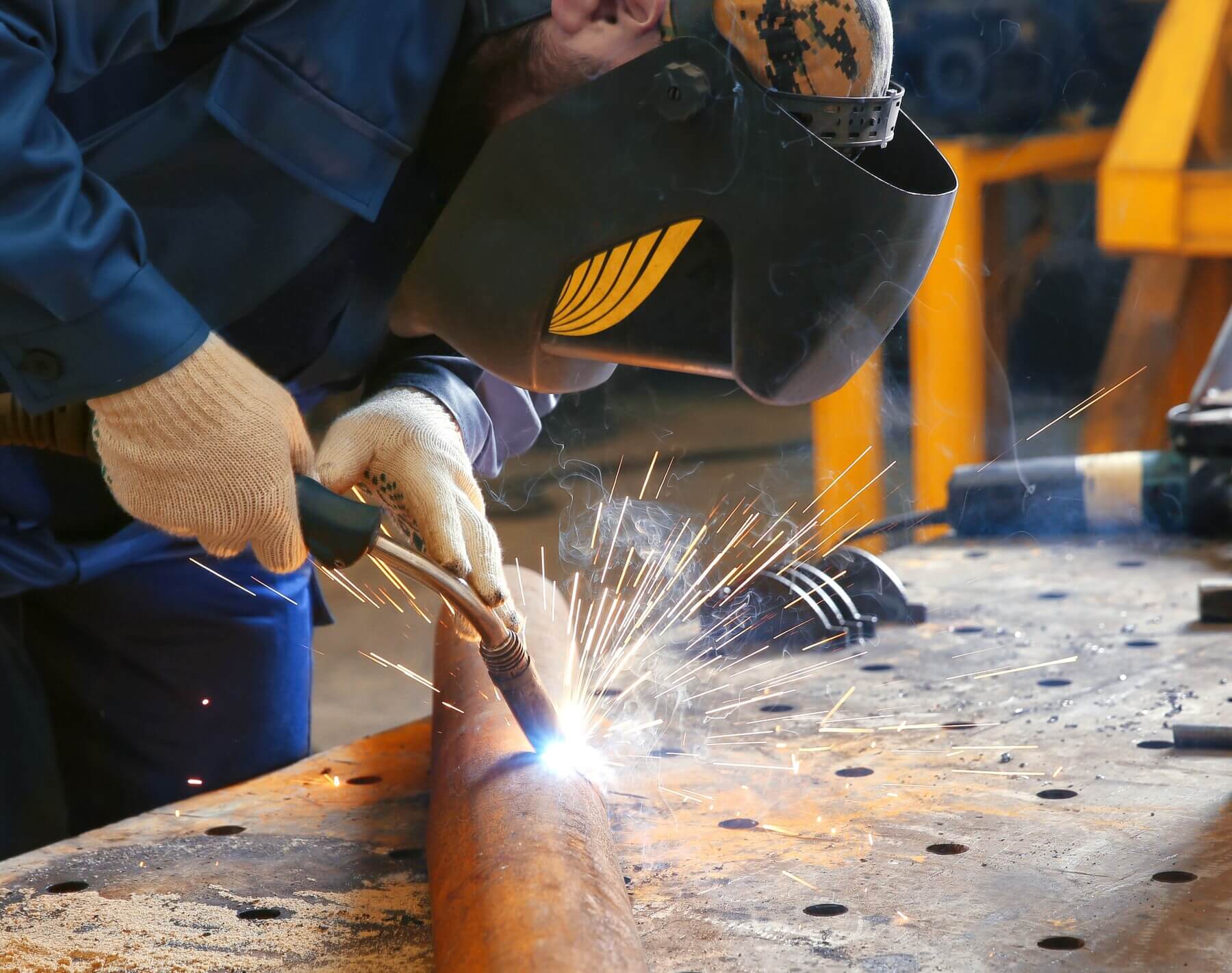 a man cutting an aluminium pipe